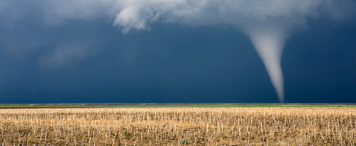 tornado in the middle of a wheat field causing damage
